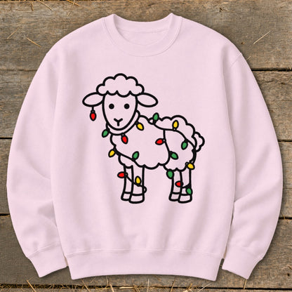 A light pink crewneck sweatshirt features a black outline graphic of a fluffy sheep tangled in colorful Christmas lights.