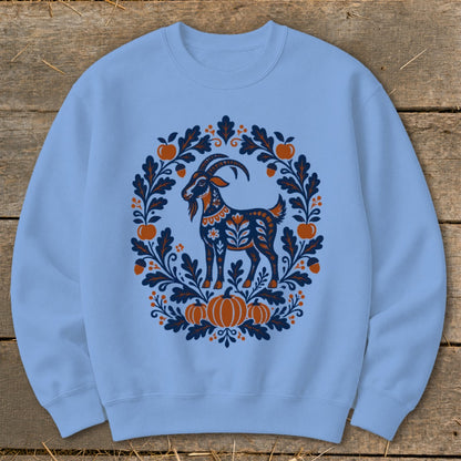 Light blue crewneck sweatshirt featuring a blue and orange folkloric goat and pumpkin wreath design.