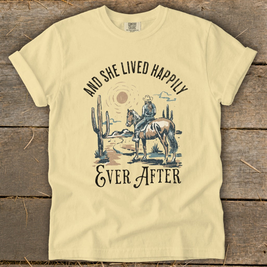 Light yellow t-shirt with desert scene: rider on horse, cacti, and text.