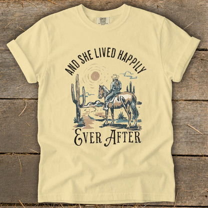 Light yellow t-shirt with desert scene: rider on horse, cacti, and text.