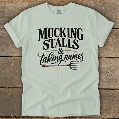 Light green t-shirt with "Mucking Stalls & Taking Names" text and a pitchfork.