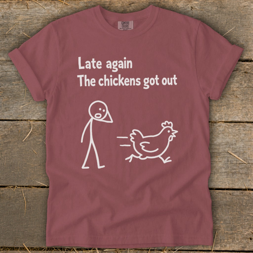 Maroon t-shirt with white text: "Late again The chickens got out" and a stick figure chasing a chicken.