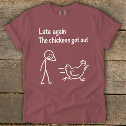 Maroon t-shirt with white text: "Late again The chickens got out" and a stick figure chasing a chicken.