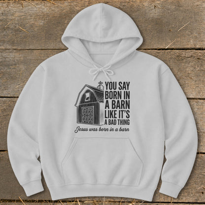 White hoodie with barn graphic and text "You say born in a barn like it's a bad thing. Jesus was born in a barn".
