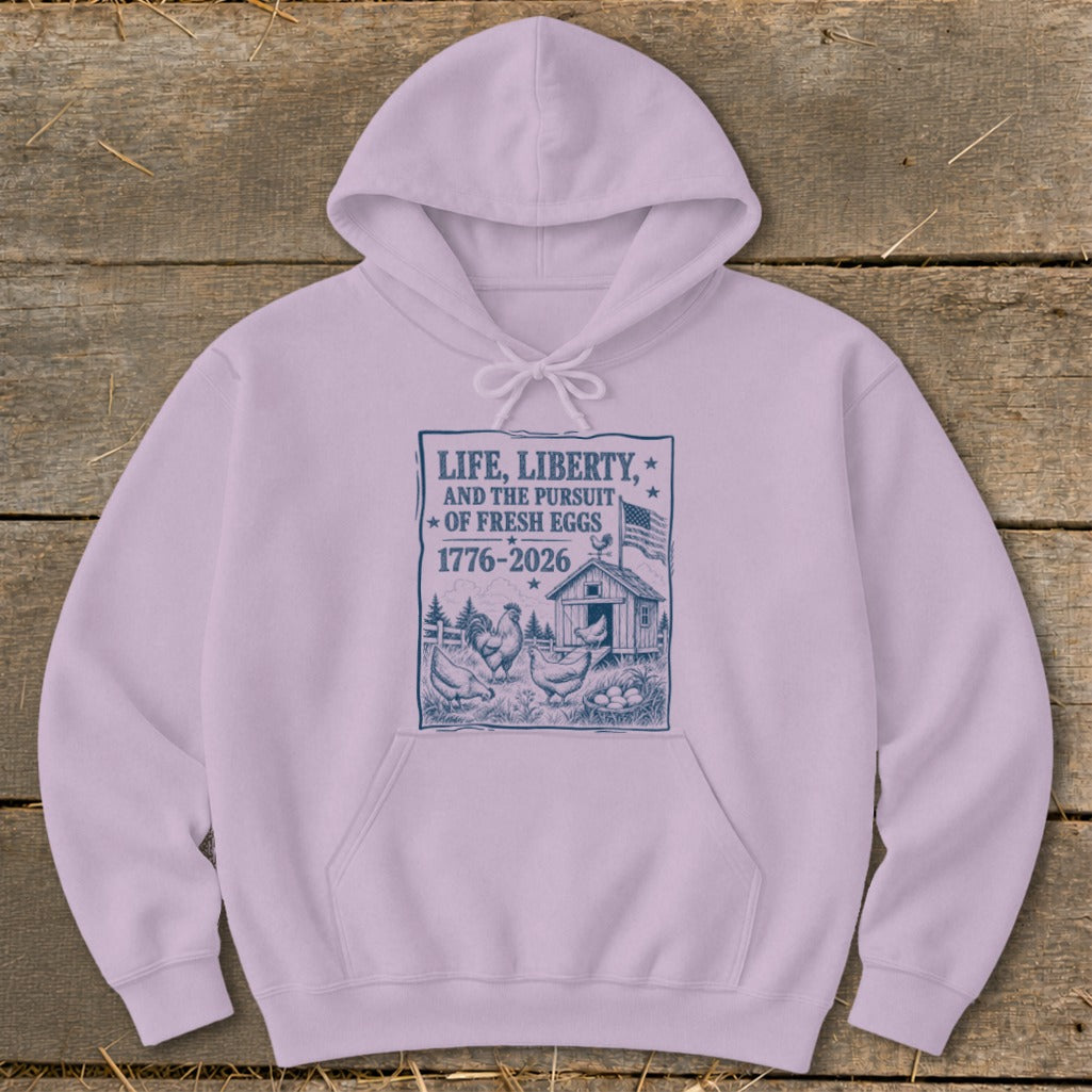 Light purple hoodie with "Life, Liberty, and the Pursuit of Fresh Eggs 1776-2026" graphic.