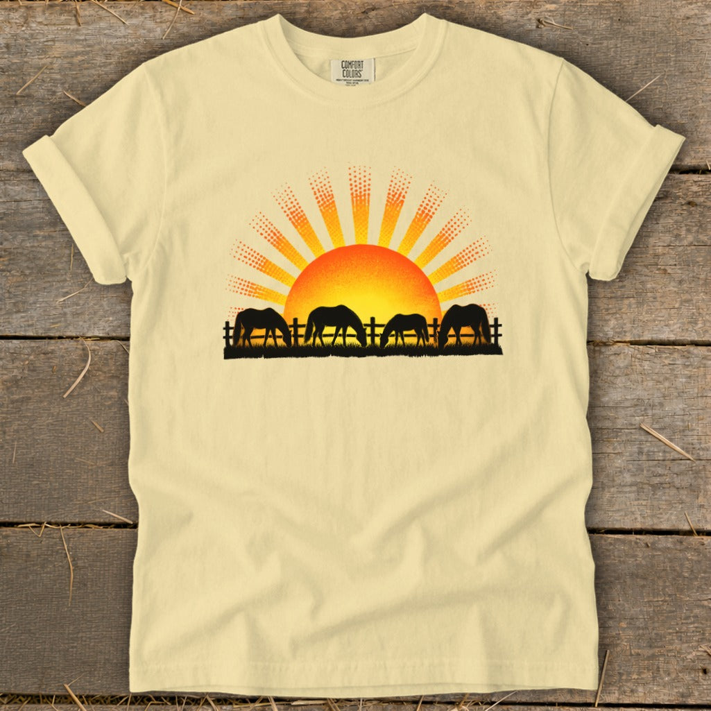 Light yellow t-shirt with horses grazing at sunrise graphic.