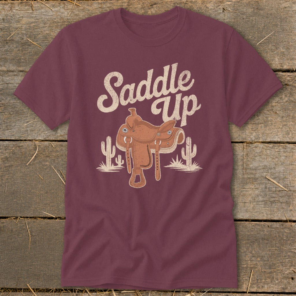 Maroon t-shirt with a cowboy saddle and cactus graphic that says "Saddle Up".