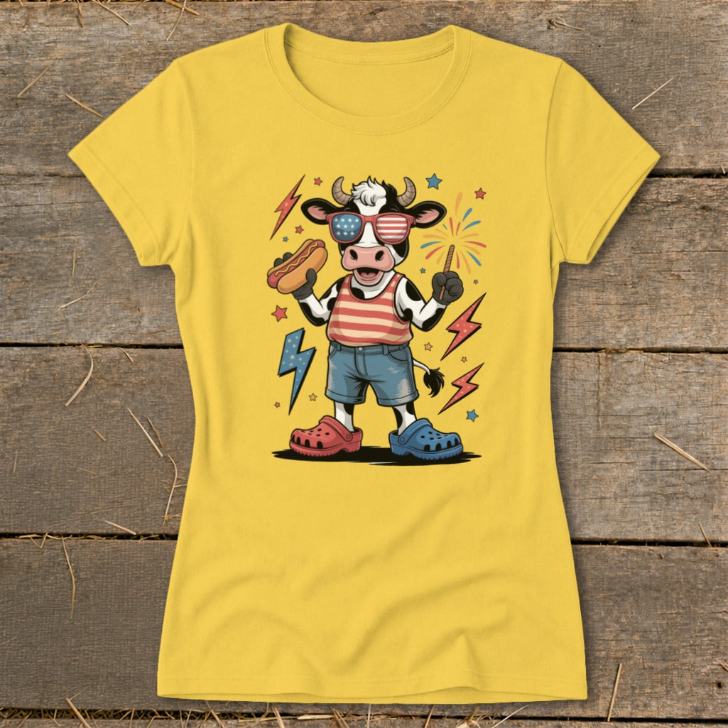 Cartoon cow wearing American flag sunglasses, holding a hot dog and sparkler.