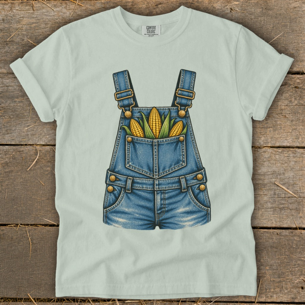 Light green t-shirt featuring a denim overall graphic with corn in the pocket.