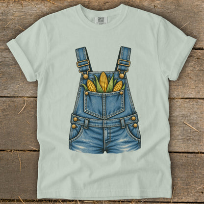 Light green t-shirt featuring a denim overall graphic with corn in the pocket.