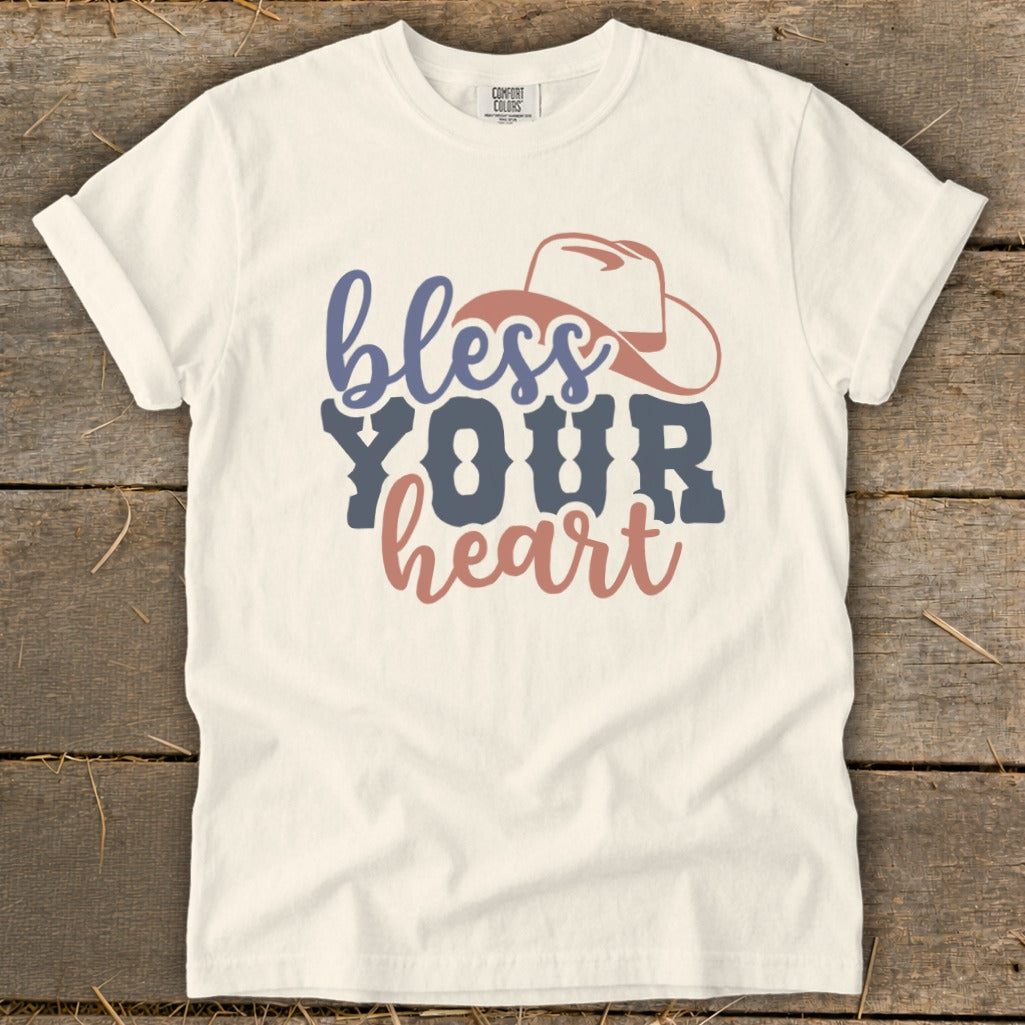 White t-shirt with "bless YOUR heart" text and a cowboy hat graphic.