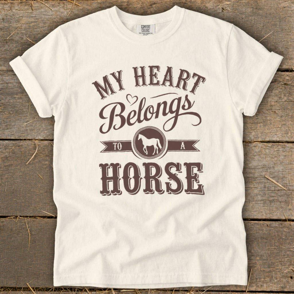 White t-shirt with brown text "My Heart Belongs To A Horse" and horse silhouette.