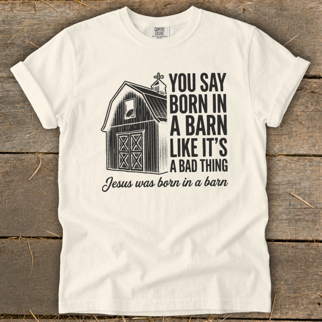 White t-shirt with a barn graphic and text "You say born in a barn like it's a bad thing Jesus was born in a barn".