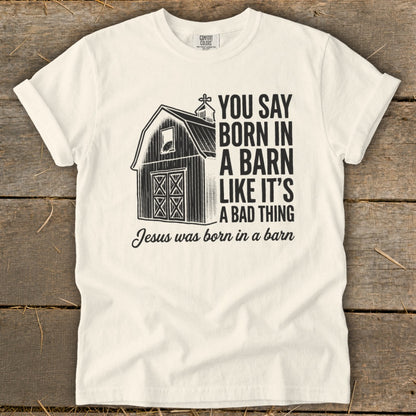 White t-shirt with a barn graphic and text "You say born in a barn like it's a bad thing Jesus was born in a barn".