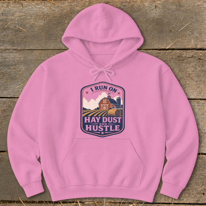 Pink hoodie with "I Run On Hay Dust And Hustle" farm graphic.