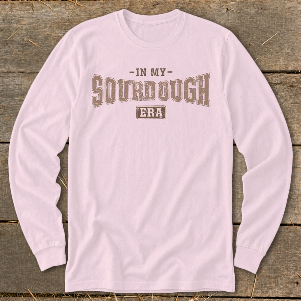 Pink long sleeve shirt with text "-IN MY- SOURDOUGH ERA" in brown.