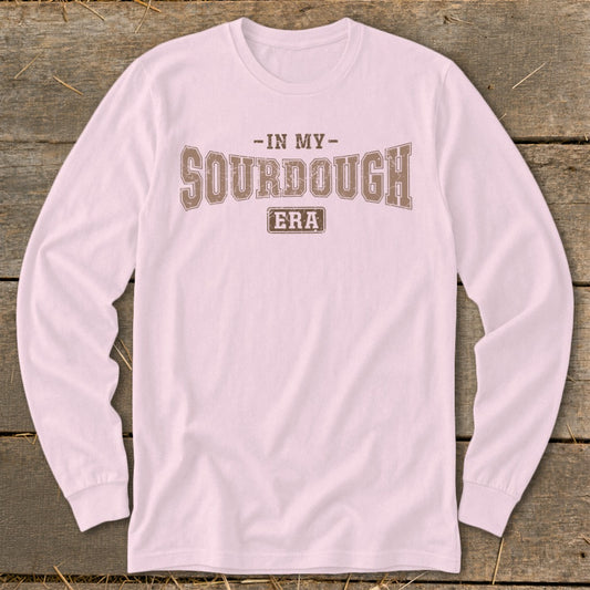 Pink long sleeve shirt with text "-IN MY- SOURDOUGH ERA" in brown.