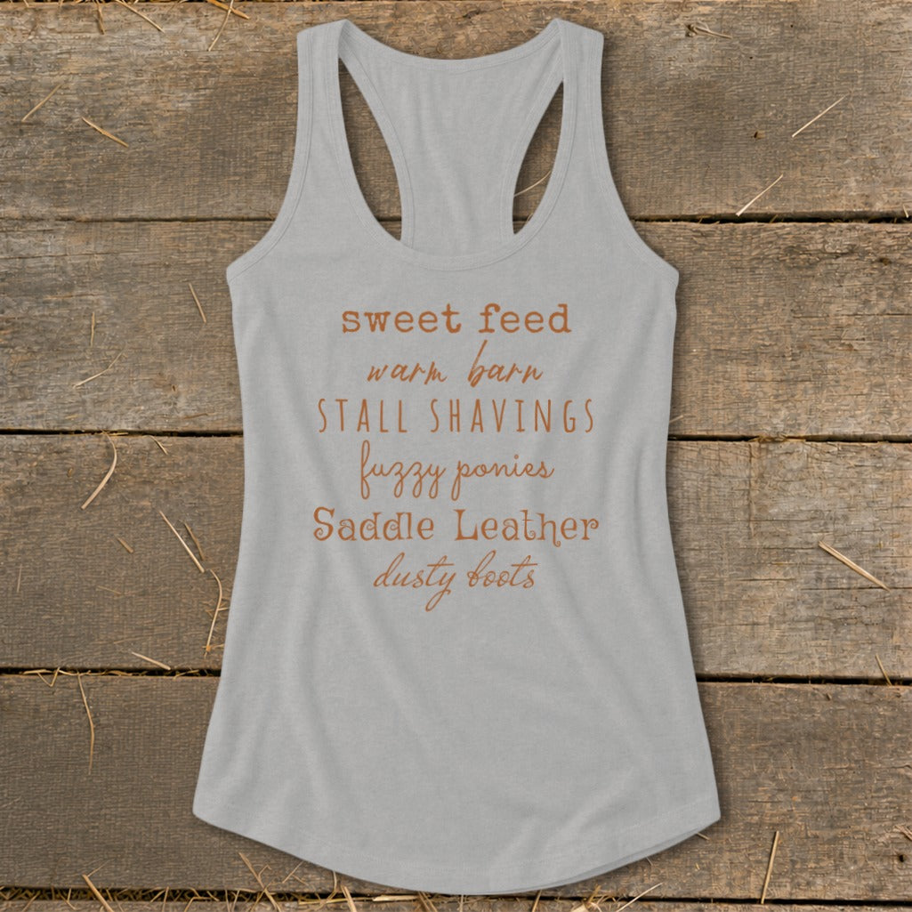 Grey tank top with text: sweet feed, warm barn, STALL SHAVINGS, fuzzy ponies, Saddle Leather, dusty boots.
