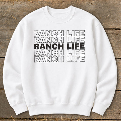 A white crewneck sweatshirt featuring five stacked lines of text reading RANCH LIFE.