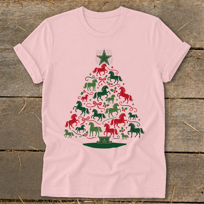 Pink t-shirt with a Christmas tree design made of red and green horses and holly.