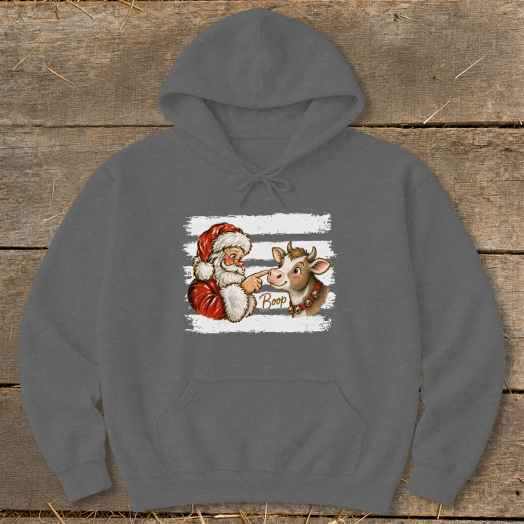 Santa booping a cow on the nose with the word "Boop".