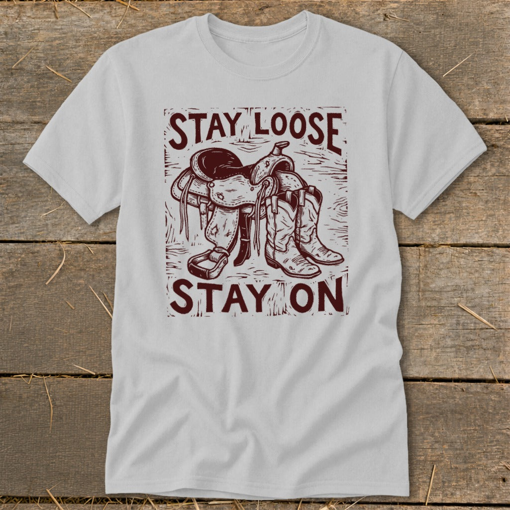 Light gray t-shirt with "STAY LOOSE STAY ON" text and saddle and boots graphic.