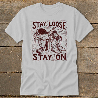 Light gray t-shirt with "STAY LOOSE STAY ON" text and saddle and boots graphic.