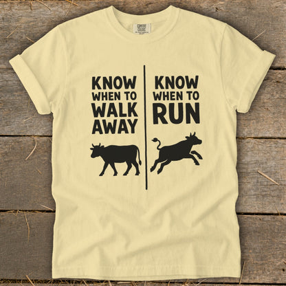 Light yellow t-shirt with black text and cow graphics: "Know When to Walk Away" and "Know When to Run".