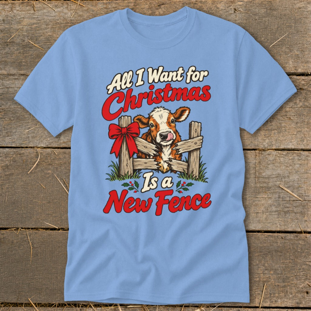Light blue t-shirt with a cow peeking over a fence with text "All I Want for Christmas Is a New Fence".