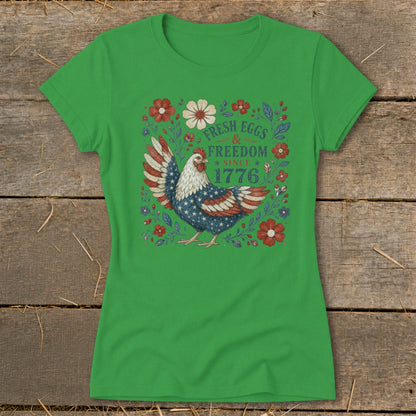 Green t-shirt with a chicken design featuring American flag wings and text "Fresh Eggs & Freedom Since 1776".
