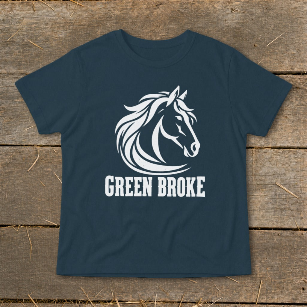Dark blue t-shirt featuring a white horse head logo and the text GREEN BROKE, laid flat on wooden planks.