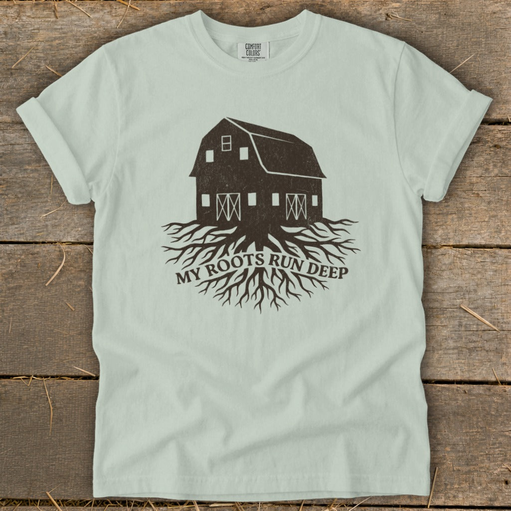 Barn with roots graphic and text "MY ROOTS RUN DEEP" on light t-shirt.
