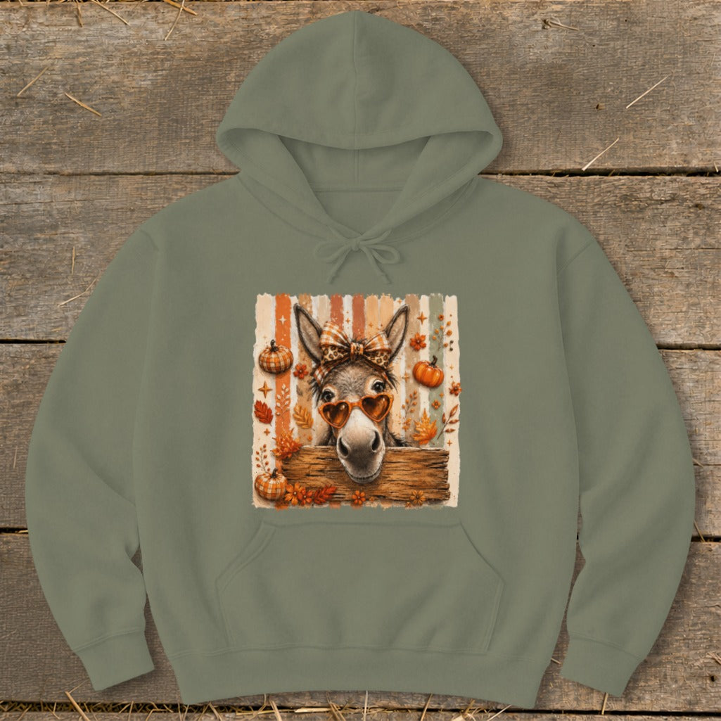 Donkey wearing heart sunglasses and a bow, with pumpkins and autumn leaves.