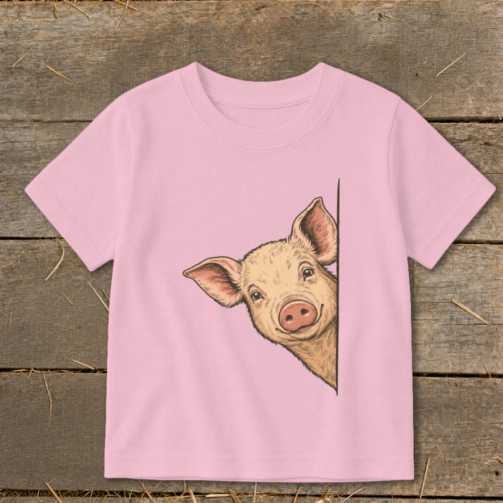 Pink t-shirt with a drawing of a pig peeking from behind a corner.