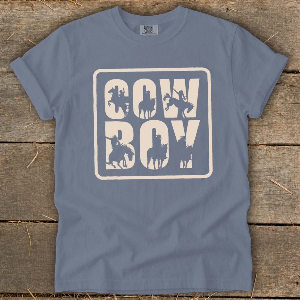 Blue t-shirt with "COW BOY" text and cowboy silhouettes within a rounded rectangle.
