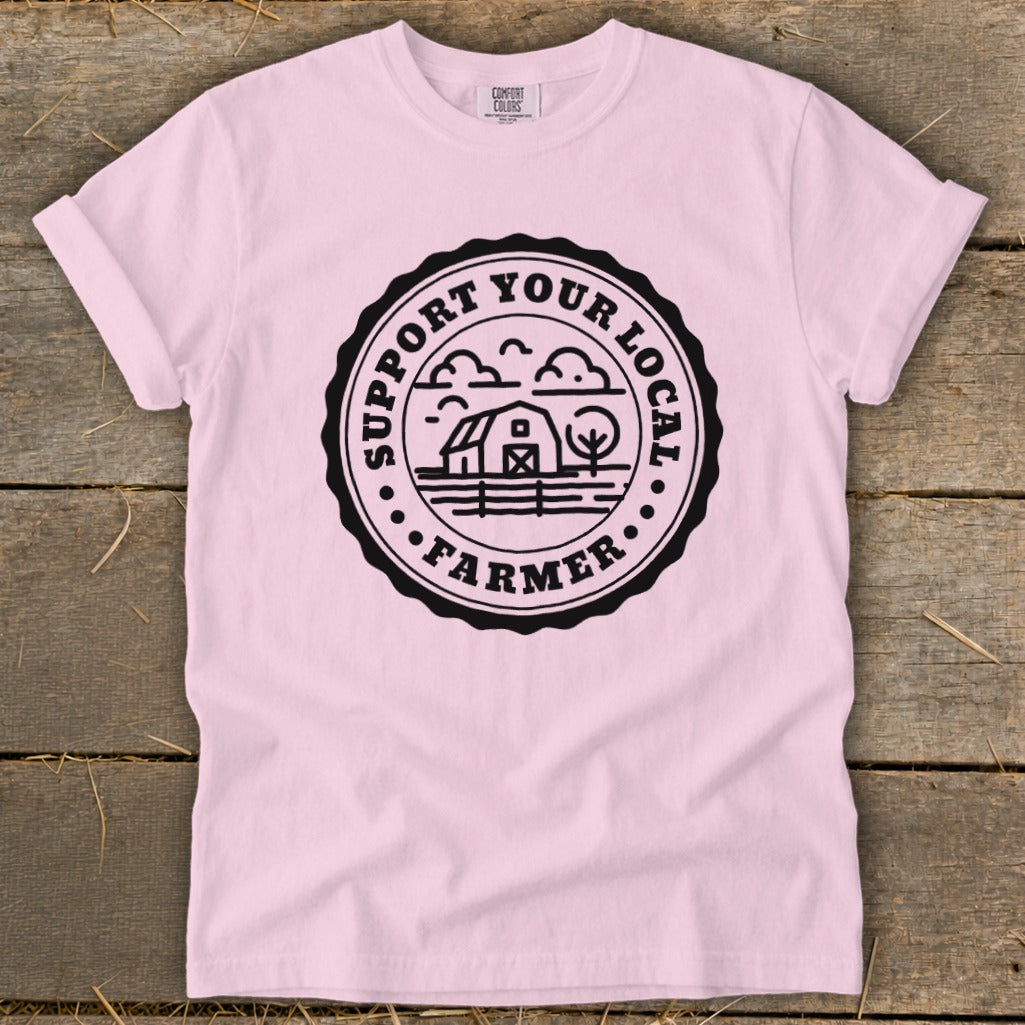 Pink t-shirt with "Support Your Local Farmer" emblem featuring a barn, tree, and clouds.