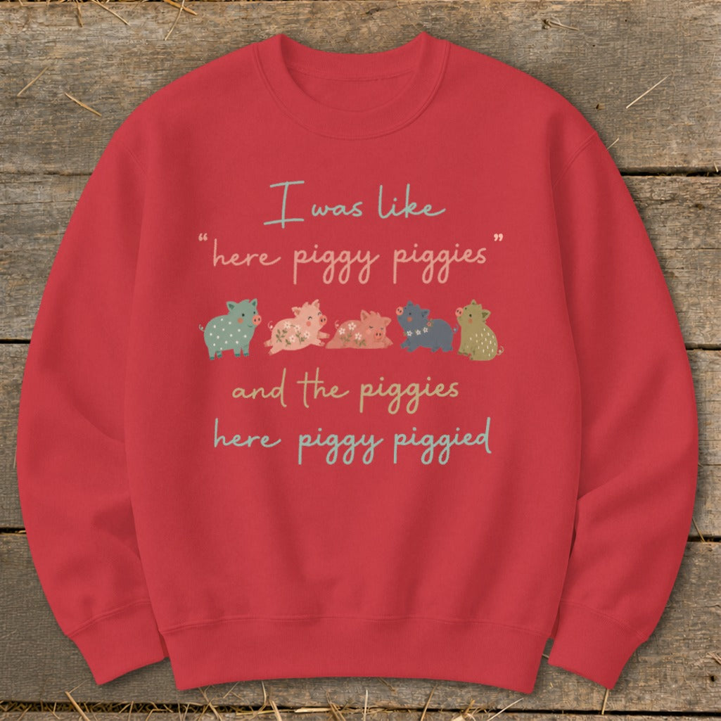 Red sweatshirt with text and cartoon pigs saying "I was like 'here piggy piggies' and the piggies here piggy piggied".