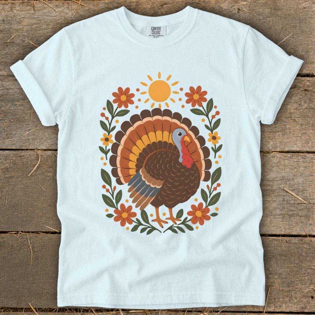 White t-shirt with a colorful turkey design and floral border.
