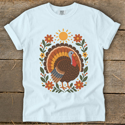 White t-shirt with a colorful turkey design and floral border.