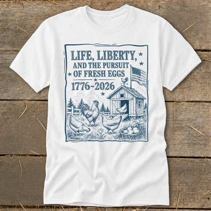 White t-shirt with graphic of farm scene, chickens, and text "Life, Liberty, and the Pursuit of Fresh Eggs".