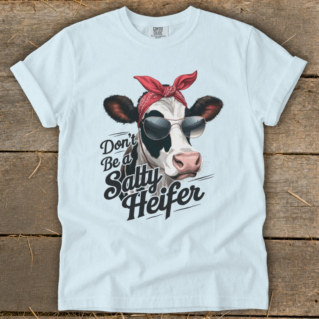 White t-shirt with a black and white cow wearing sunglasses and a red bandana, reading "Don't Be a Salty Heifer".