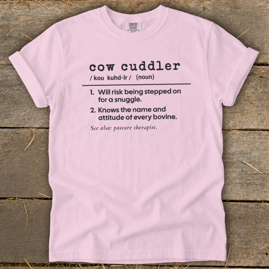 Pink t-shirt with "cow cuddler" definition: risk stepped on for snuggle, knows bovine name.