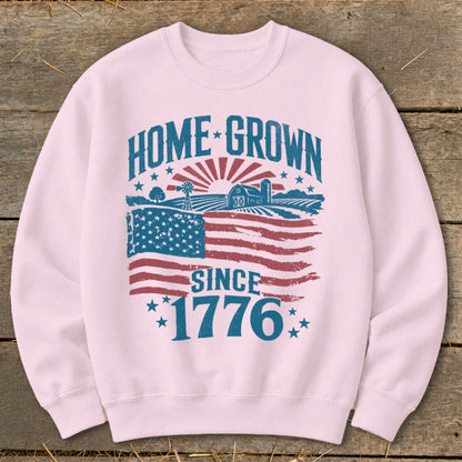 Pink sweatshirt with "Home Grown Since 1776" graphic and American flag detail.