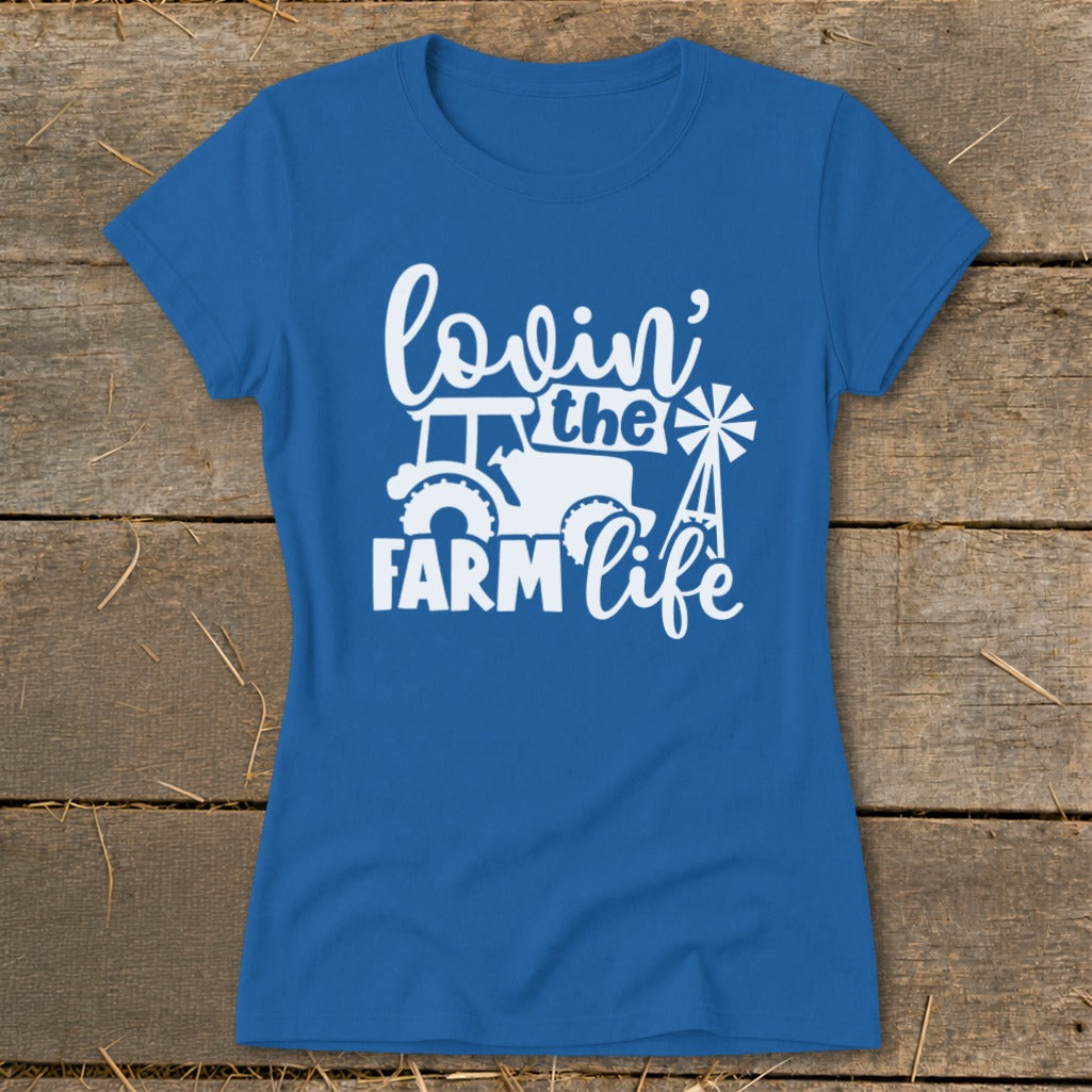 Blue t-shirt with white graphic reading "lovin' the FARM life" and featuring a tractor and windmill.