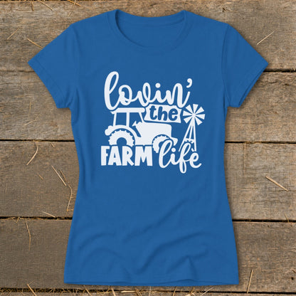 Blue t-shirt with white graphic reading "lovin' the FARM life" and featuring a tractor and windmill.