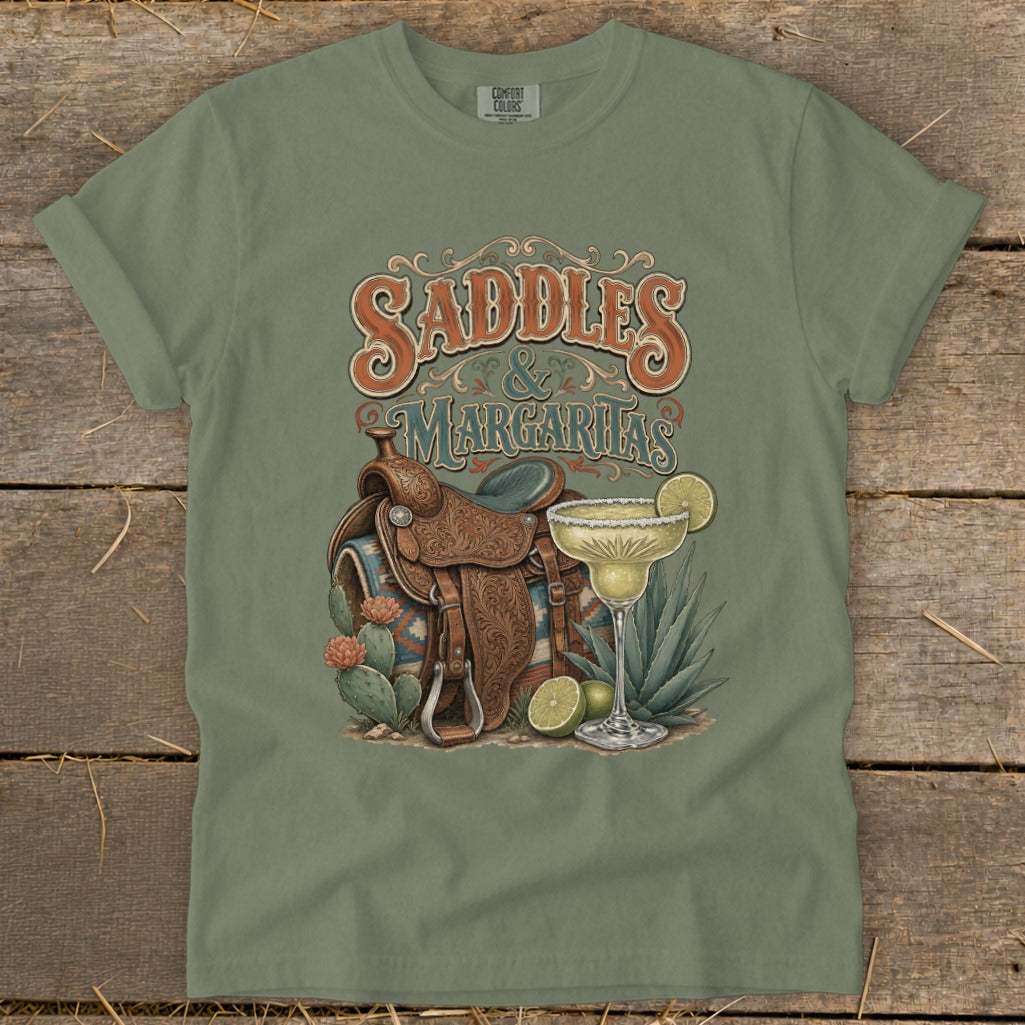 Saddles & Margaritas graphic on a green t-shirt with a western saddle and margarita.