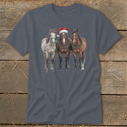 Three horses in wreaths and Christmas lights, one wearing a Santa hat.