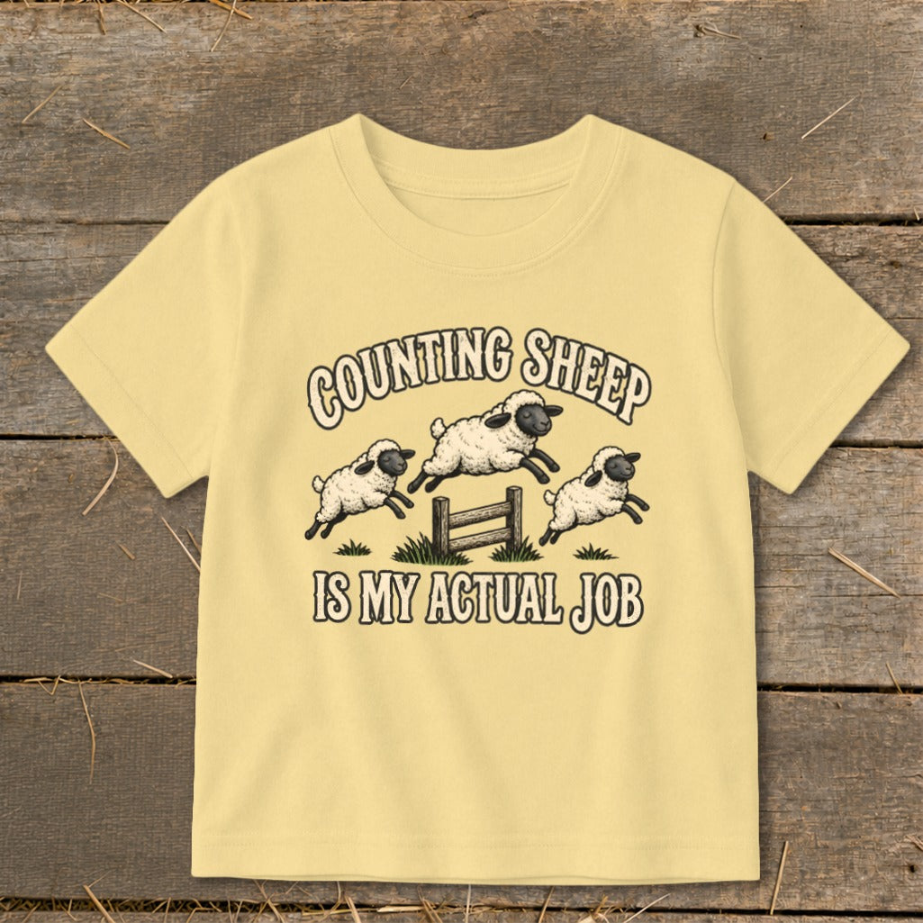 Yellow t-shirt with three jumping sheep and text "COUNTING SHEEP IS MY ACTUAL JOB".