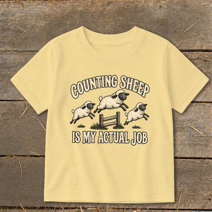 Yellow t-shirt with three jumping sheep and text "COUNTING SHEEP IS MY ACTUAL JOB".