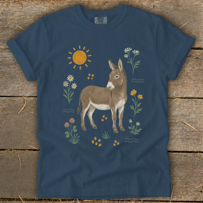 Donkey surrounded by flowers, sun, and waves on a navy t-shirt.